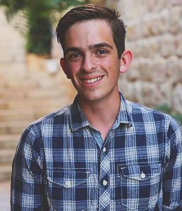 A smiling young man in a blue checked shirt. Fellow Yoni Altman-Shafer.