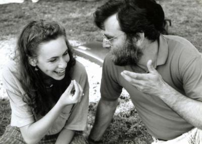 A black and white photo of a female Fellow in deep conversation with an educator.  They are both making gestures with their hands and smiling.