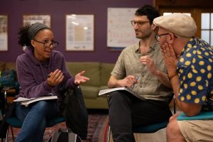 A female Bronfman Fellow is in the middle of a deep discussion with two educators, who lean forward intently.