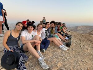 A group of Fellows sitting outside during sunrise.