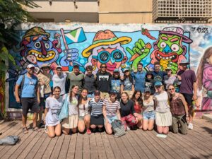 Fellows in front of a graffiti mural.