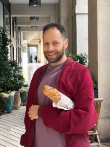 Picture of Oded, holding a baguette.