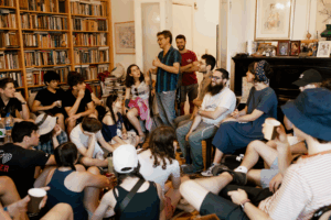 A speaker talks to the Fellows in a library.
